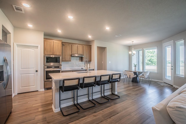 146 Chester Rd, Springtown, TX 76082 - kitchen with stainless steel appliances, a sink, wood finished floors, a kitchen breakfast bar, and a center island with sink
