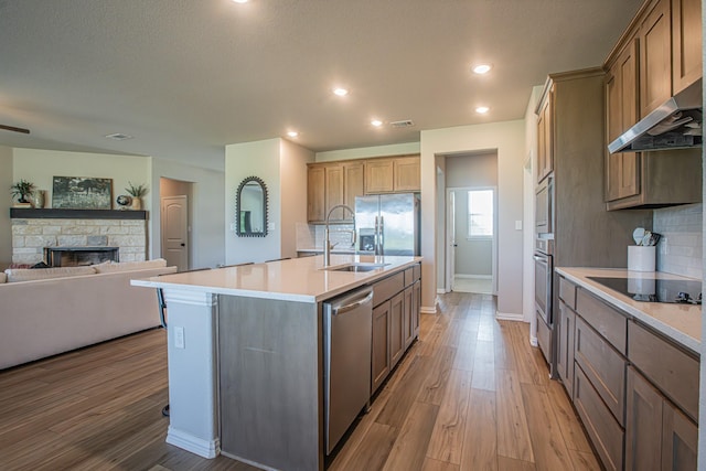 146 Chester Rd, Springtown, TX 76082 - kitchen featuring appliances with stainless steel finishes, a sink, light wood-style flooring, baseboards, and open floor plan