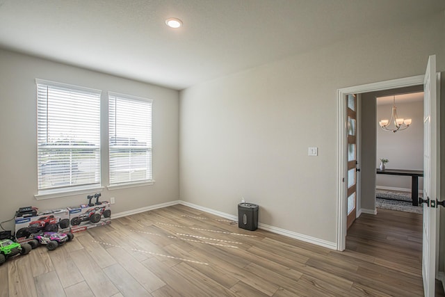 146 Chester Rd, Springtown, TX 76082 - unfurnished room featuring a chandelier, wood finished floors, and baseboards