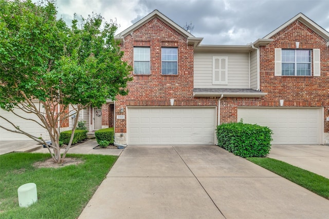 townhome / multi-family property featuring a garage, concrete driveway, and brick siding
