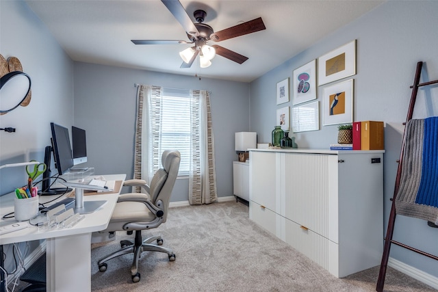 home office with light colored carpet, ceiling fan, and baseboards