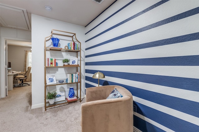 living area featuring attic access, light colored carpet, and a desk