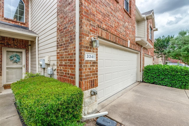 view of home's exterior featuring brick siding, an attached garage, and concrete driveway