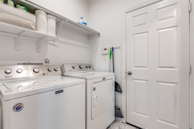 washroom with washer and clothes dryer and light marble finish flooring