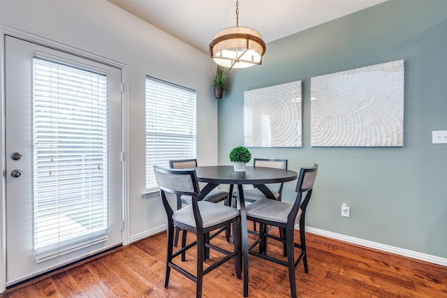 dining space featuring wood finished floors and baseboards