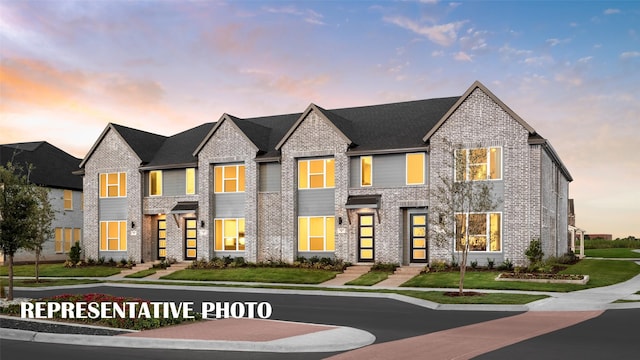 view of front of property with brick siding and a front lawn