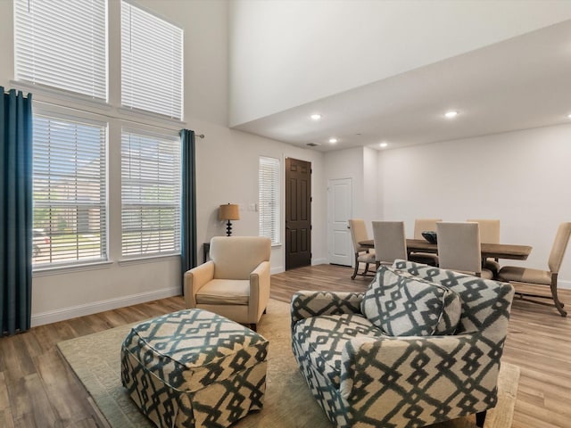 7335 Panicum Dr, Frisco, TX 75033 - living room featuring light wood-style flooring, baseboards, a towering ceiling, and recessed lighting