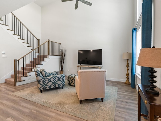7335 Panicum Dr, Frisco, TX 75033 - living area with wood finished floors, a high ceiling, stairs, a ceiling fan, and baseboards