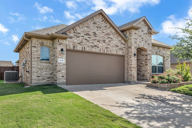 516 Smart Strike Trl, Granbury, TX 76049 - french country style house featuring concrete driveway, central AC unit, an attached garage, a front yard, and brick siding