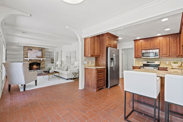 7609 Spring Valley Rd, Dallas, TX 75254 - kitchen featuring appliances with stainless steel finishes, a fireplace, recessed lighting, open floor plan, and brick patterned flooring