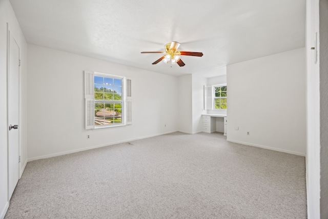 7609 Spring Valley Rd, Dallas, TX 75254 - unfurnished bedroom featuring light carpet, baseboards, and a ceiling fan