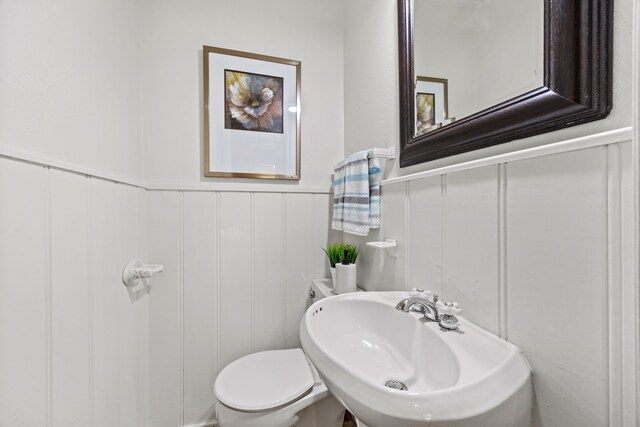 7609 Spring Valley Rd, Dallas, TX 75254 - bathroom featuring a decorative wall, a sink, a wainscoted wall, and toilet