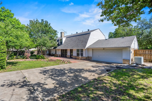 7609 Spring Valley Rd, Dallas, TX 75254 - dutch colonial with central AC, a shingled roof, a chimney, a garage, and driveway