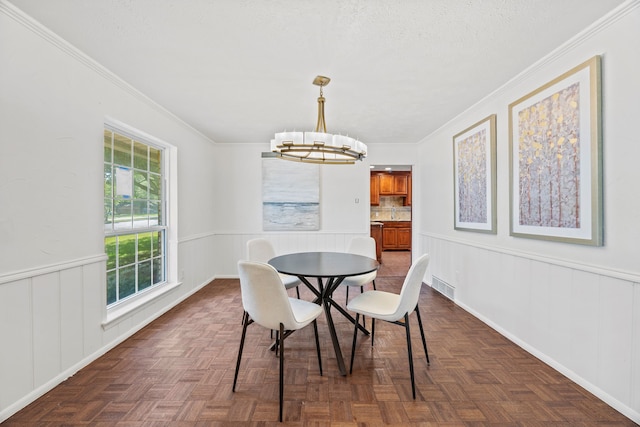 7609 Spring Valley Rd, Dallas, TX 75254 - dining space featuring a chandelier, wainscoting, ornamental molding, and a decorative wall
