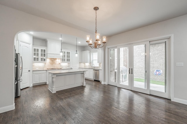 670 Bridge St, Coppell, TX 75019 - kitchen featuring stainless steel appliances, white cabinets, backsplash, a chandelier, and dark wood-style floors