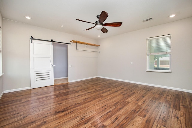 301 Sycamore St, Bardwell, TX 75101 - unfurnished room featuring ceiling fan, a barn door, wood finished floors, recessed lighting, and baseboards