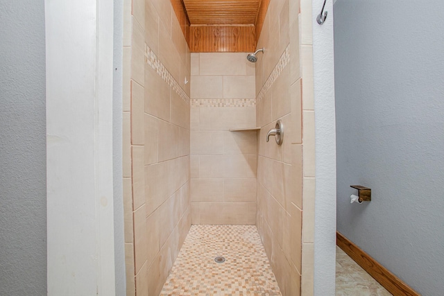 301 Sycamore St, Bardwell, TX 75101 - bathroom with a tile shower, wood ceiling, and a textured wall
