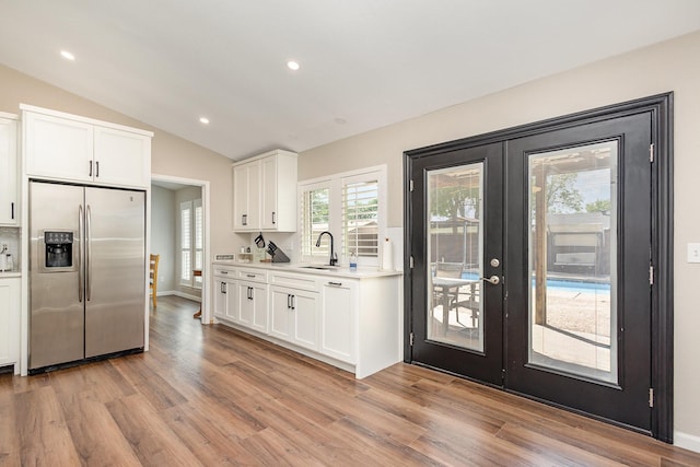 3105 Kensington Dr, Mesquite, TX 75150 - kitchen featuring stainless steel fridge, a sink, french doors, light wood finished floors, and vaulted ceiling