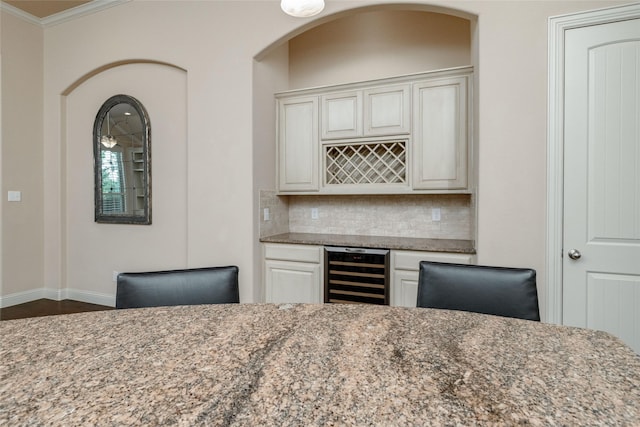 3900 Plum Vista Pl, Arlington, TX 76005 - indoor dry bar featuring beverage cooler, ornamental molding, backsplash, baseboards, and dark wood-type flooring