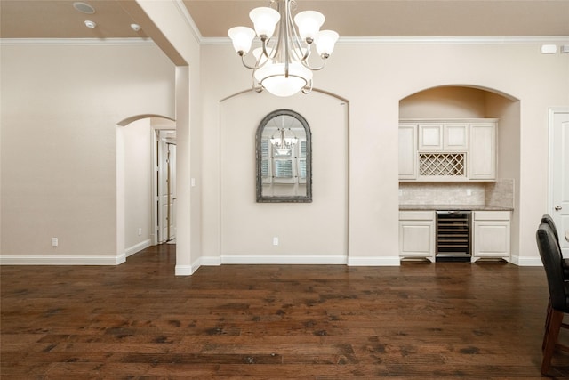 3900 Plum Vista Pl, Arlington, TX 76005 - unfurnished dining area featuring beverage cooler, a chandelier, ornamental molding, a dry bar, and arched walkways