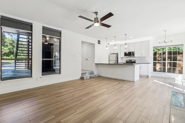 7525 Holly Hill Dr Unit 17, Dallas, TX 75231 - unfurnished living room featuring plenty of natural light, light wood-style flooring, a chandelier, and a ceiling fan