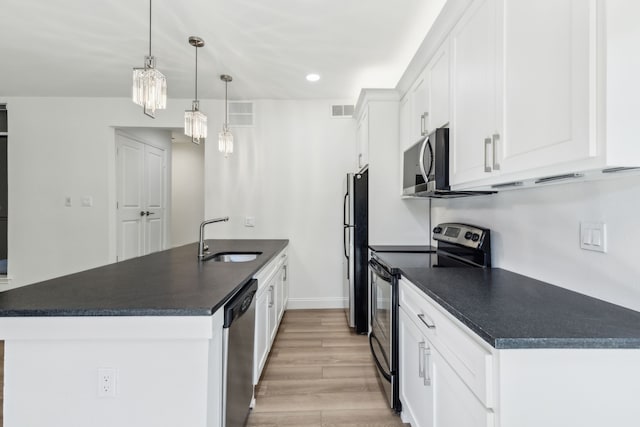 7525 Holly Hill Dr Unit 17, Dallas, TX 75231 - kitchen featuring stainless steel appliances, a sink, dark countertops, white cabinets, and light wood-type flooring