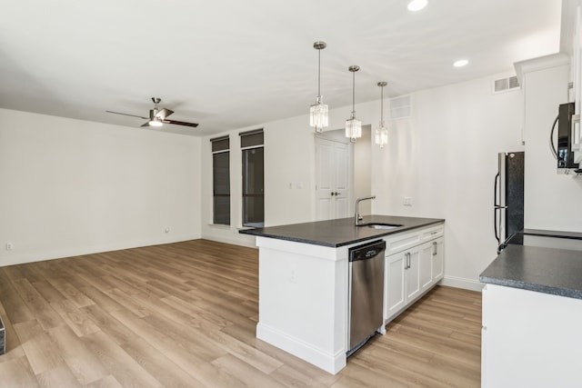 7525 Holly Hill Dr Unit 17, Dallas, TX 75231 - kitchen featuring a sink, dark countertops, a peninsula, appliances with stainless steel finishes, and recessed lighting