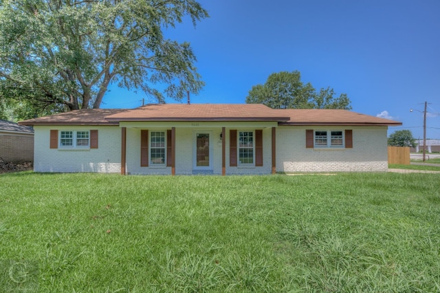 single story home featuring brick siding, a front yard, and a porch
