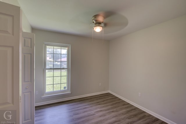 unfurnished room featuring ceiling fan, dark wood-type flooring, and baseboards