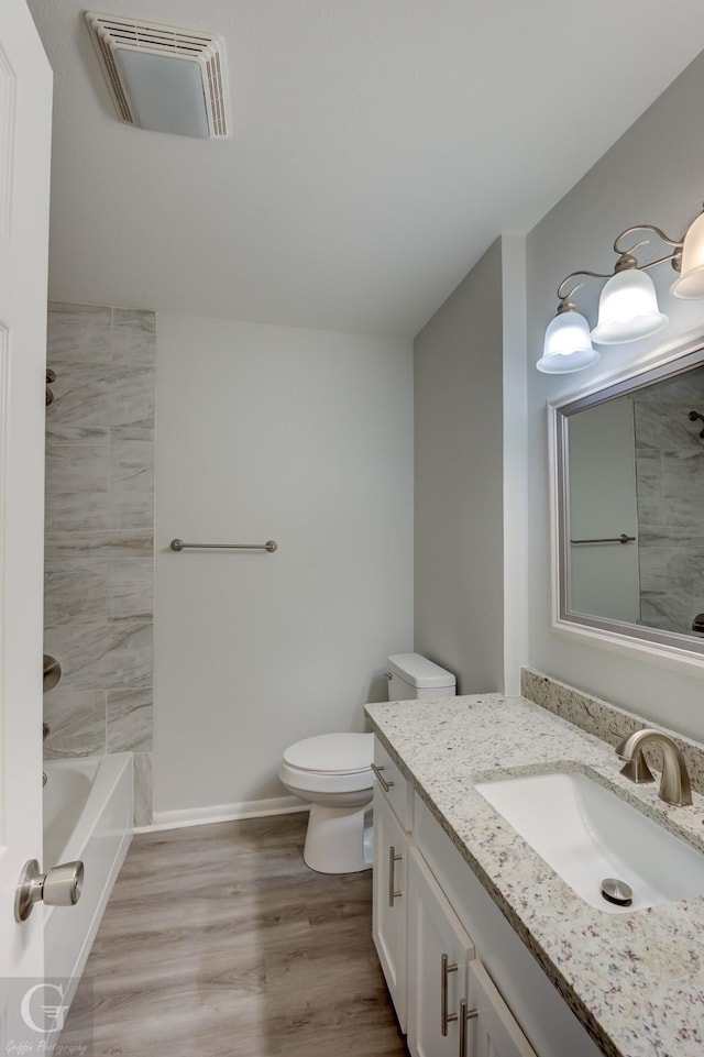 full bath with wood finished floors, vanity, toilet,  shower combination, and baseboards