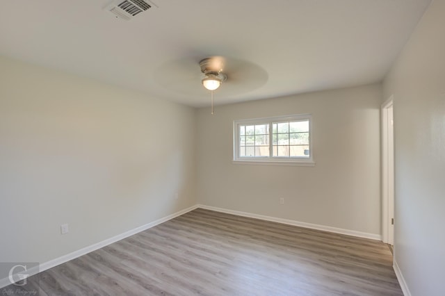 spare room featuring wood finished floors, baseboards, and a ceiling fan