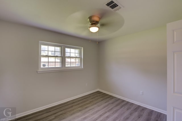 spare room featuring ceiling fan, wood finished floors, and baseboards