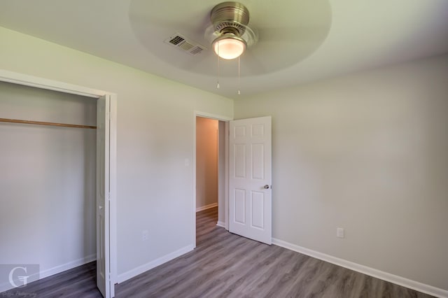 unfurnished bedroom featuring wood finished floors, baseboards, a closet, and a ceiling fan