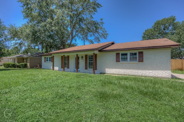 single story home featuring brick siding, a front lawn, and covered porch