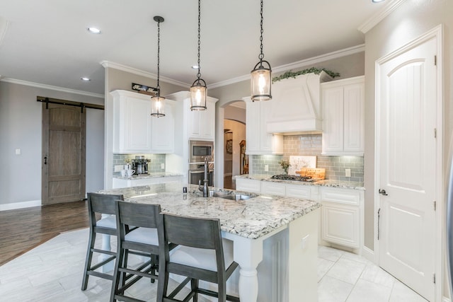 1061 Circle J Trl, Prosper, TX 75078 - kitchen featuring a sink, appliances with stainless steel finishes, custom range hood, arched walkways, and a kitchen island with sink