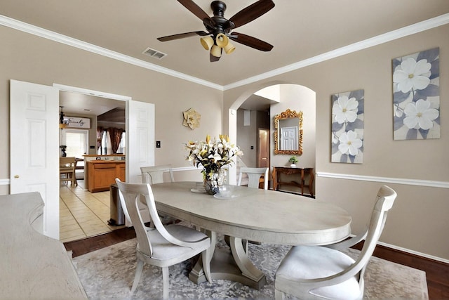 1942 Garrison Way, Garland, TX 75040 - dining space with crown molding, a ceiling fan, arched walkways, wood finished floors, and baseboards