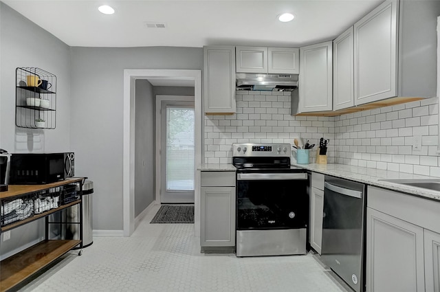 514 W Baker St, Denison, TX 75020 - kitchen featuring appliances with stainless steel finishes, under cabinet range hood, decorative backsplash, light stone countertops, and recessed lighting