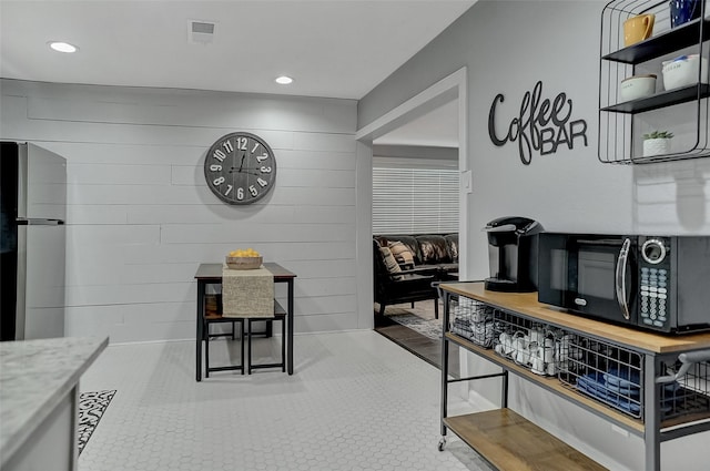 514 W Baker St, Denison, TX 75020 - kitchen with black microwave, freestanding refrigerator, recessed lighting, and stone counters