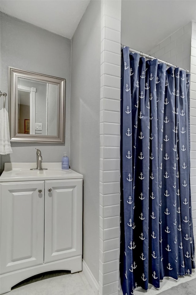 514 W Baker St, Denison, TX 75020 - bathroom with a sink, curtained shower, and baseboards