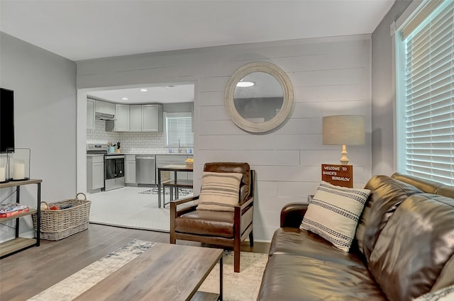 514 W Baker St, Denison, TX 75020 - living area featuring light wood-style flooring and wood walls