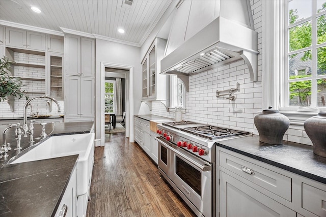 kitchen featuring double oven range, custom range hood, decorative backsplash, dark wood finished floors, and ornamental molding