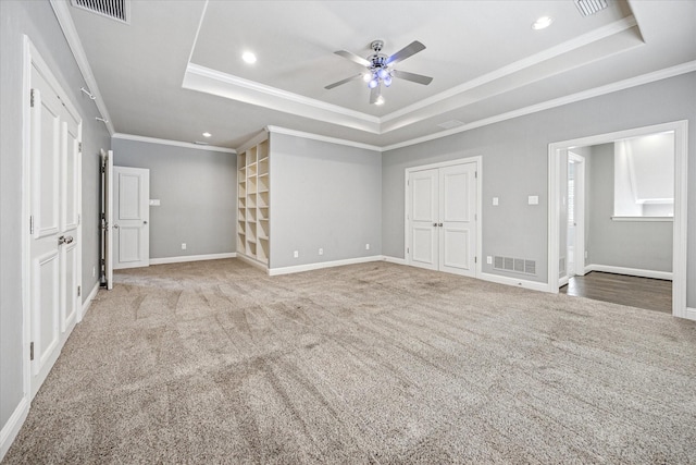 unfurnished bedroom featuring a tray ceiling, ornamental molding, recessed lighting, carpet flooring, and baseboards