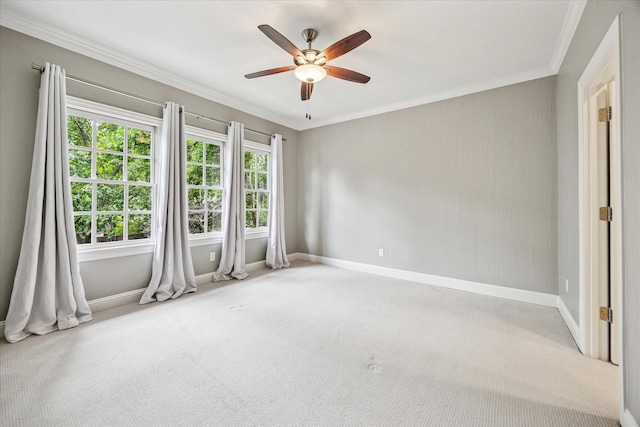 spare room with baseboards, carpet flooring, ceiling fan, and crown molding