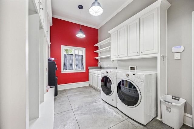 clothes washing area with cabinet space, separate washer and dryer, crown molding, and baseboards