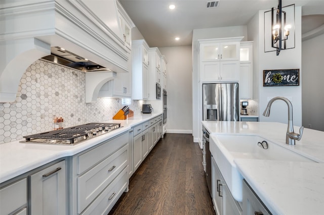 2813 Dorset, The Colony, TX 75056 - kitchen with appliances with stainless steel finishes, dark wood-style floors, a sink, hanging light fixtures, and decorative backsplash