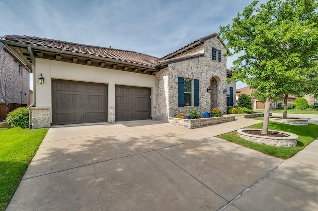 2813 Dorset, The Colony, TX 75056 - mediterranean / spanish-style home with a tiled roof, stone siding, concrete driveway, and a garage