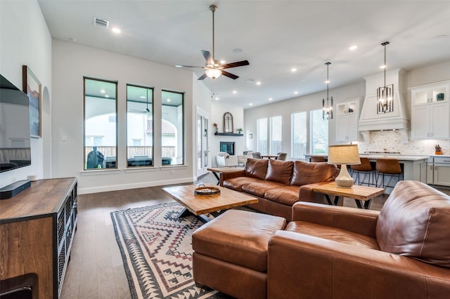 2813 Dorset, The Colony, TX 75056 - living area featuring ceiling fan, dark wood finished floors, recessed lighting, a glass covered fireplace, and baseboards