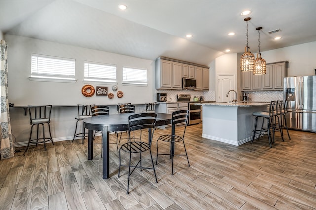 5712 Demi Sec Dr, Mckinney, TX 75070 - kitchen featuring appliances with stainless steel finishes, gray cabinets, plenty of natural light, decorative backsplash, and vaulted ceiling