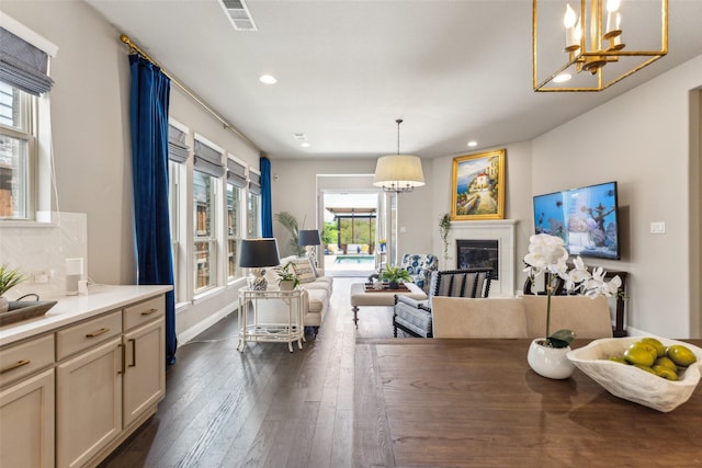 3460 Begonia Ln, Irving, TX 75038 - dining space with a chandelier, recessed lighting, dark wood-style floors, a glass covered fireplace, and baseboards