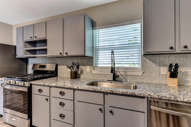 401 W Acheson St, Denison, TX 75020 - kitchen featuring stainless steel appliances, a sink, gray cabinetry, and backsplash